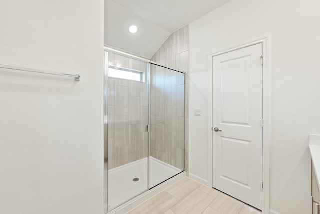 bathroom featuring walk in shower and lofted ceiling