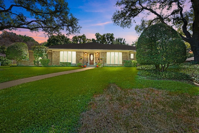 ranch-style home with a lawn