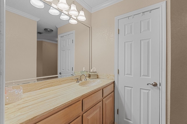 bathroom with ornamental molding, a textured ceiling, and vanity