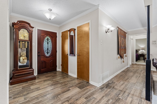 foyer featuring a textured ceiling, crown molding, and hardwood / wood-style floors