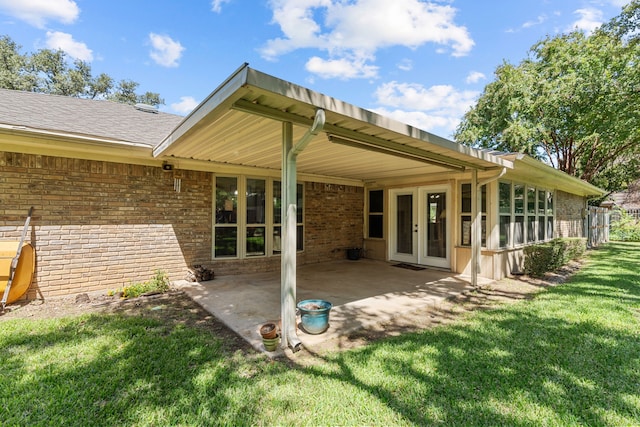 rear view of property featuring a lawn and a patio