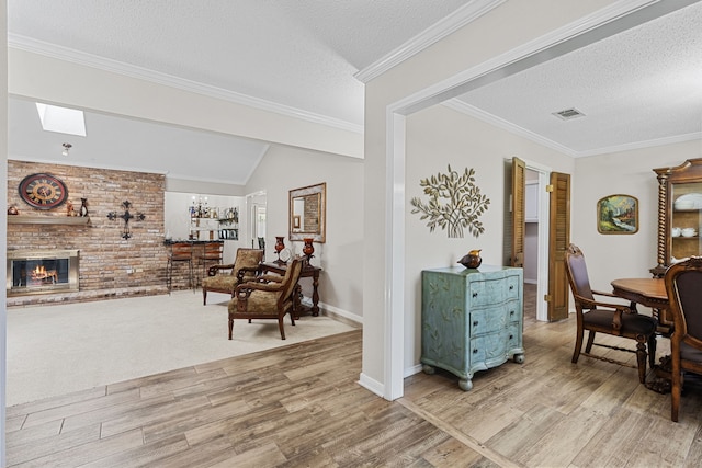 interior space featuring a textured ceiling, light hardwood / wood-style flooring, a fireplace, crown molding, and vaulted ceiling