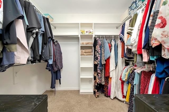 walk in closet featuring light colored carpet