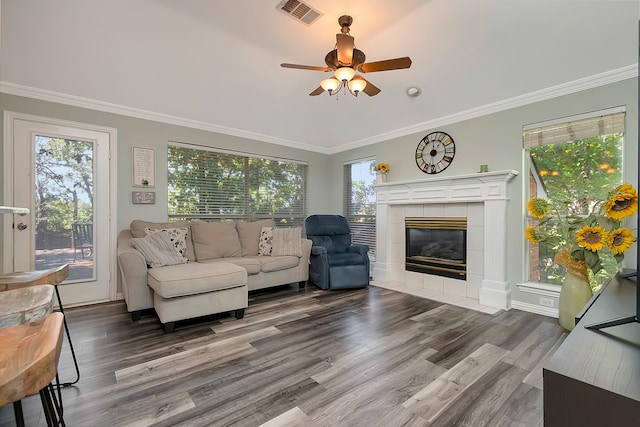 living room with crown molding, a fireplace, dark hardwood / wood-style floors, and ceiling fan