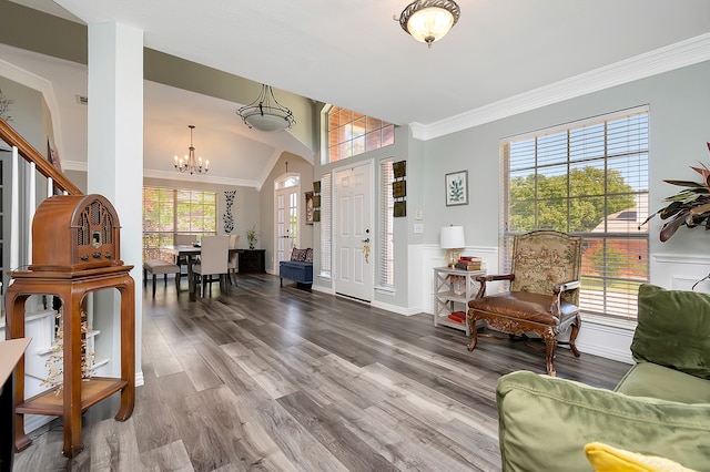 entrance foyer with a notable chandelier, crown molding, lofted ceiling, and hardwood / wood-style flooring