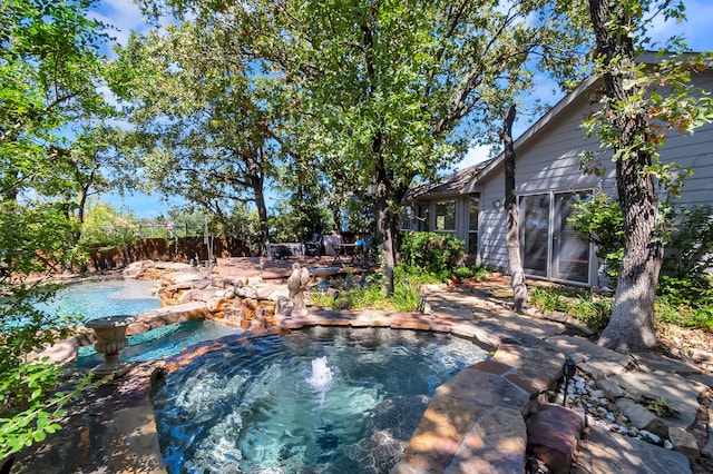 view of pool featuring a patio, an in ground hot tub, and a garden pond