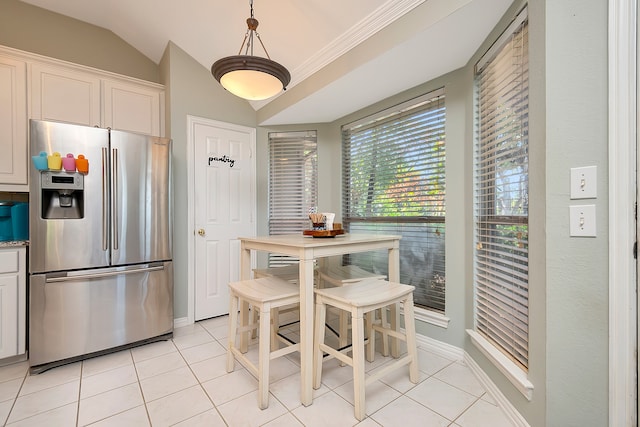 kitchen with pendant lighting, stainless steel fridge with ice dispenser, white cabinetry, vaulted ceiling, and light tile patterned floors