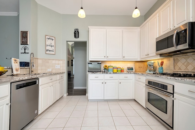 kitchen featuring stainless steel appliances, hanging light fixtures, and white cabinetry