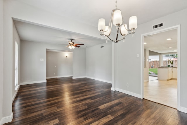 spare room with ceiling fan with notable chandelier and dark hardwood / wood-style floors