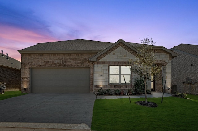 view of front of house with a garage and a lawn