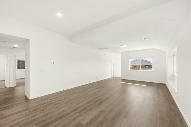 unfurnished room featuring dark hardwood / wood-style flooring and vaulted ceiling