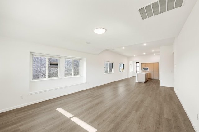 unfurnished living room with light wood-type flooring and a wealth of natural light