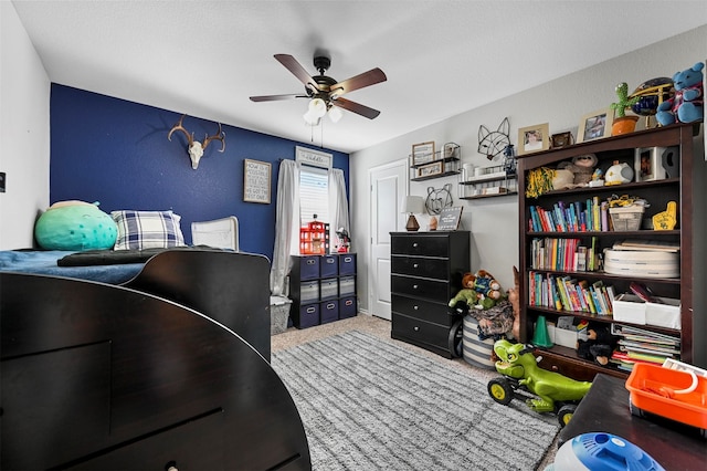 bedroom featuring light carpet, ceiling fan, and a textured ceiling