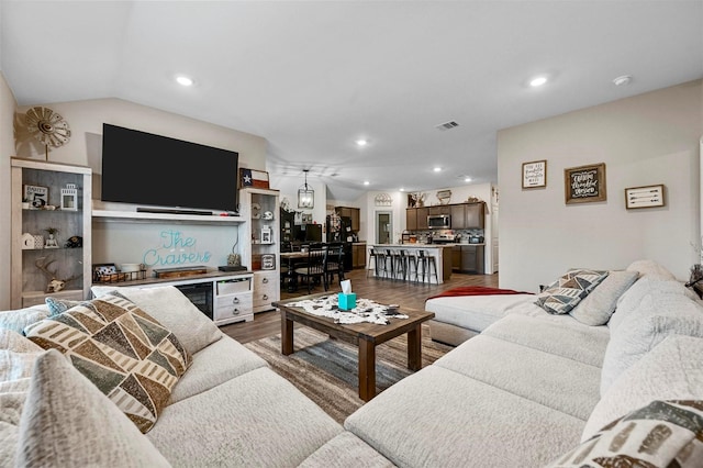 living area featuring visible vents, wood finished floors, lofted ceiling, and recessed lighting