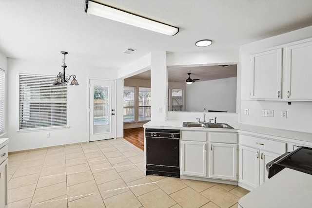 kitchen featuring white cabinets, light tile patterned floors, sink, black dishwasher, and ceiling fan with notable chandelier