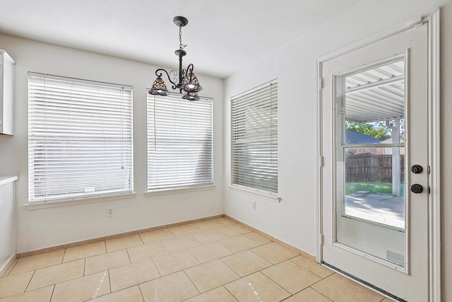 unfurnished dining area featuring light tile patterned floors and a notable chandelier