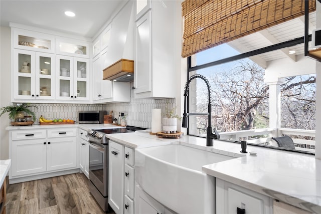 kitchen featuring backsplash, white cabinetry, appliances with stainless steel finishes, dark hardwood / wood-style floors, and light stone countertops