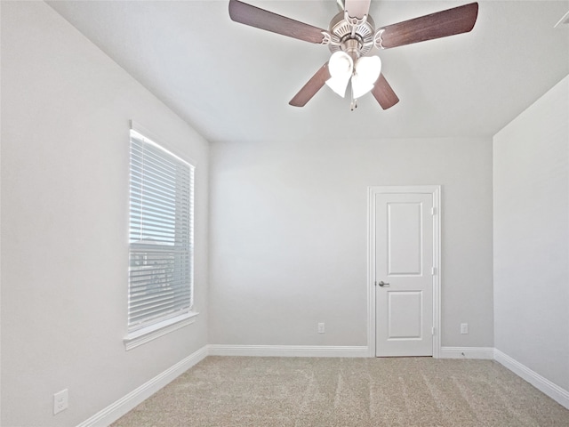 carpeted spare room featuring ceiling fan