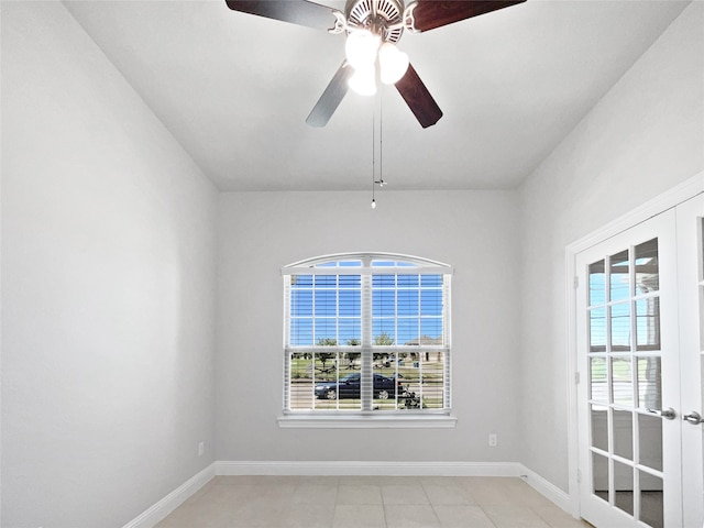 empty room with ceiling fan, light tile patterned flooring, and french doors