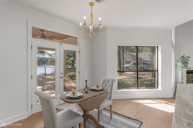 dining area with ornamental molding, light hardwood / wood-style flooring, and a healthy amount of sunlight