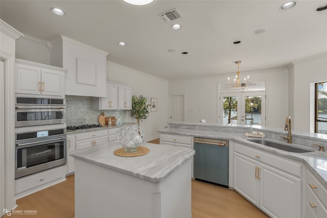 kitchen featuring stainless steel appliances, plenty of natural light, sink, and a center island