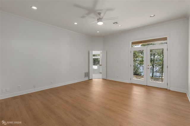 unfurnished room with crown molding, ceiling fan, french doors, and light hardwood / wood-style floors