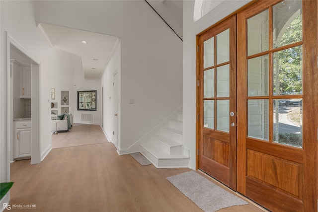 foyer with plenty of natural light, french doors, and light hardwood / wood-style flooring