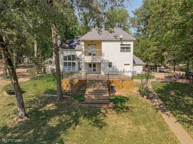 back of property with a wooden deck and a lawn