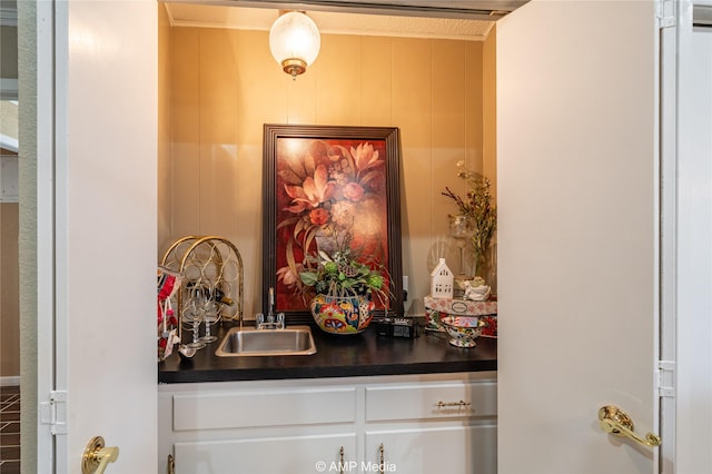 bar with white cabinetry and sink