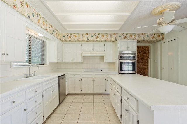 kitchen featuring ceiling fan, white cabinets, sink, stainless steel appliances, and decorative backsplash