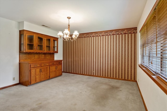 unfurnished dining area with light carpet and a chandelier