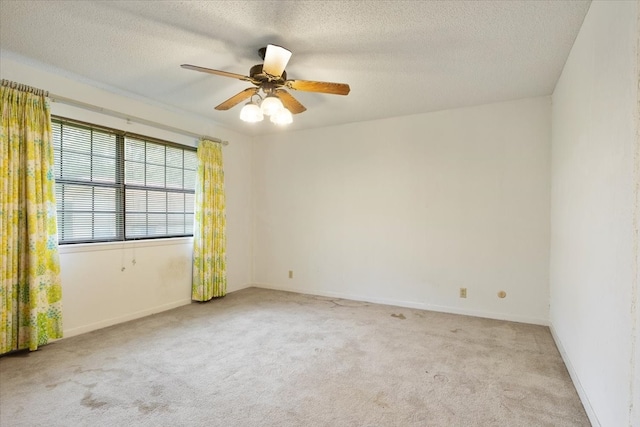 carpeted empty room featuring a textured ceiling and ceiling fan