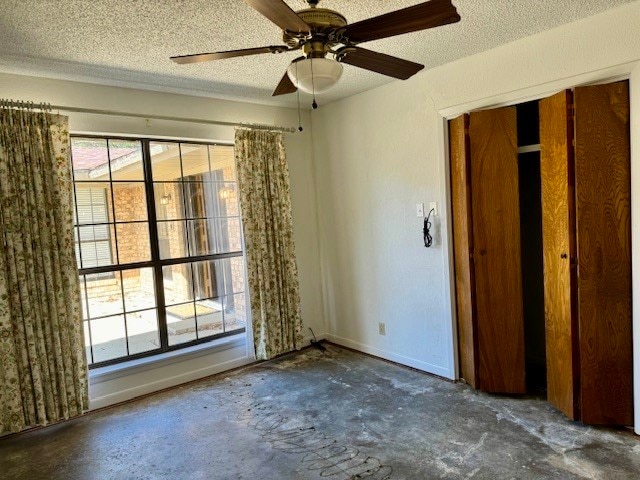 unfurnished bedroom with ceiling fan, a textured ceiling, and a closet