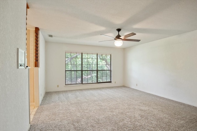 carpeted empty room with ceiling fan and a textured ceiling