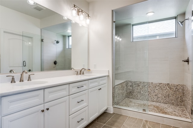 bathroom featuring vanity, tile patterned floors, and walk in shower