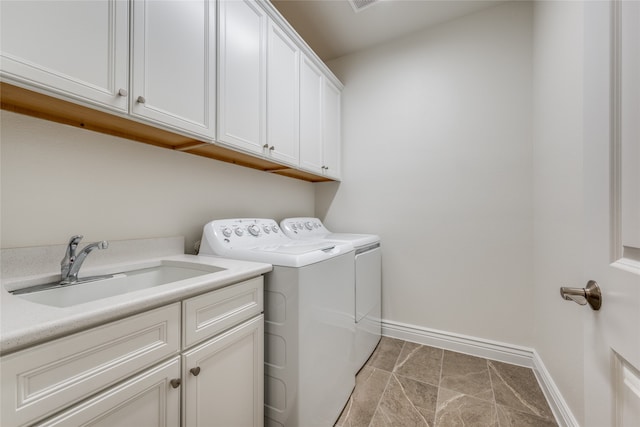 laundry room with washer and clothes dryer, light tile patterned flooring, cabinets, and sink