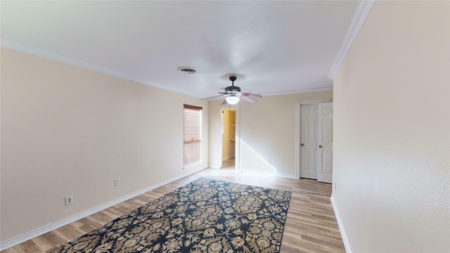 empty room with ornamental molding, ceiling fan, and light hardwood / wood-style flooring