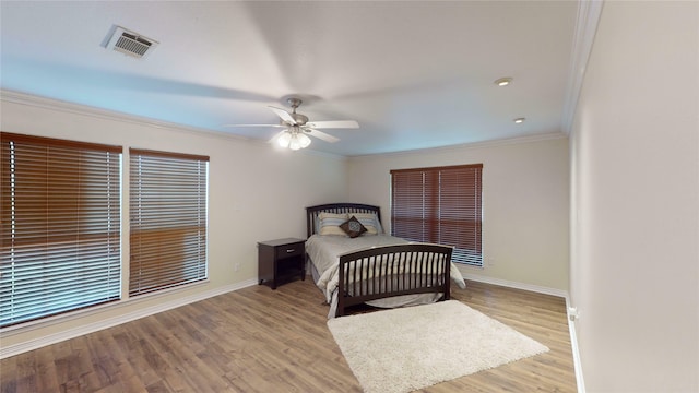 bedroom featuring light hardwood / wood-style flooring, ceiling fan, and ornamental molding