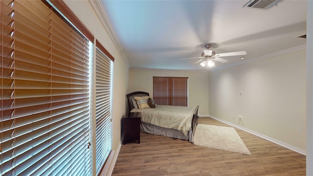 bedroom with ceiling fan, light wood-type flooring, and crown molding