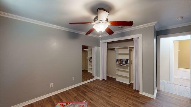 unfurnished bedroom with ceiling fan, a closet, dark hardwood / wood-style floors, and ornamental molding