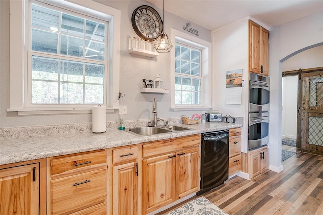 kitchen with a barn door, dishwasher, decorative light fixtures, open shelves, and a sink