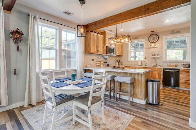 dining area with light wood-style flooring, beam ceiling, visible vents, and baseboards