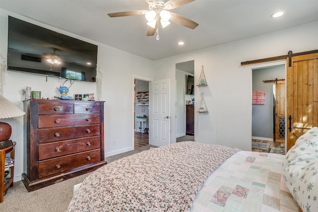 bedroom with a barn door, baseboards, light colored carpet, and recessed lighting