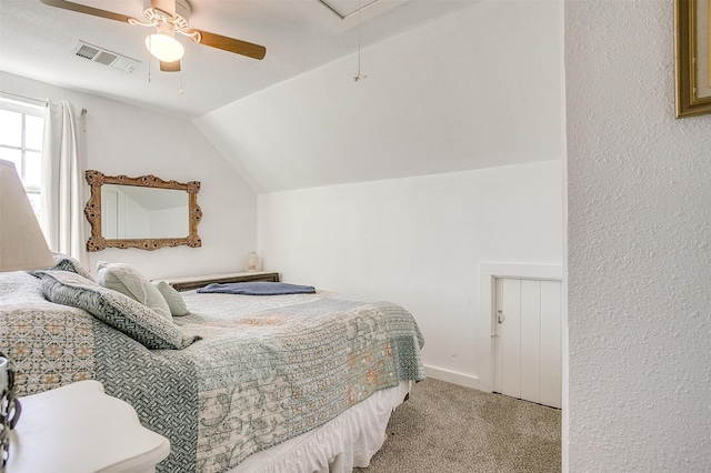 bedroom featuring lofted ceiling, ceiling fan, light colored carpet, visible vents, and attic access