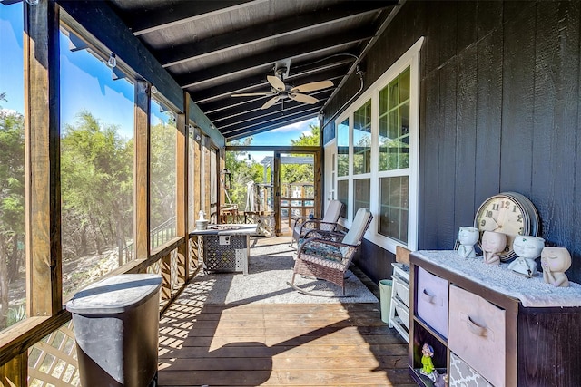 sunroom / solarium featuring lofted ceiling with beams, wood ceiling, and a ceiling fan