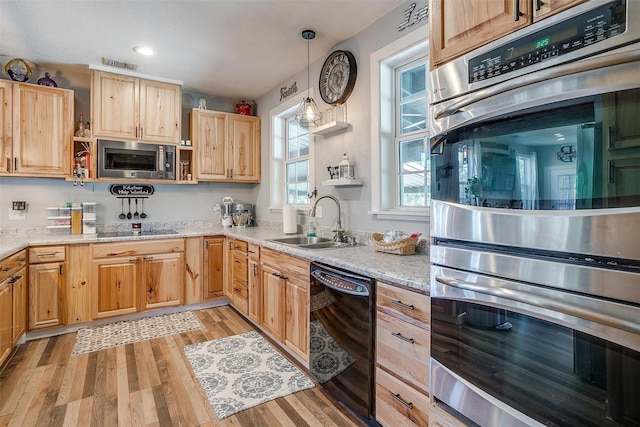 kitchen featuring light stone counters, open shelves, hanging light fixtures, a sink, and black appliances