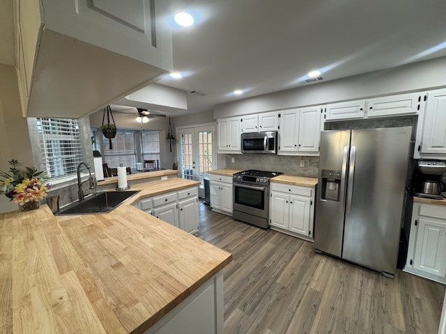 kitchen featuring white cabinetry, ceiling fan, appliances with stainless steel finishes, and wood counters