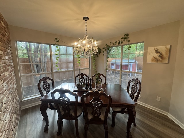 dining area with a notable chandelier, dark hardwood / wood-style flooring, and a wealth of natural light