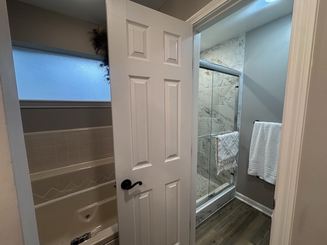 bathroom featuring wood-type flooring and separate shower and tub