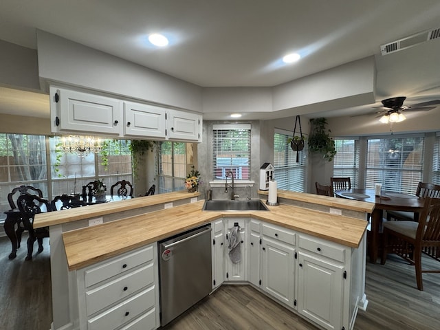 kitchen with butcher block counters, kitchen peninsula, and white cabinetry